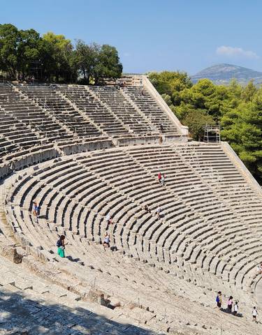Ancient amphitheater with tourists exploring.