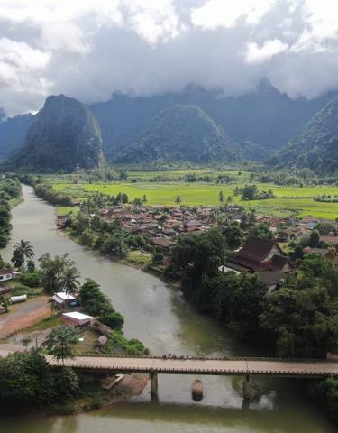 Scenic river valley with lush greenery and mountains.