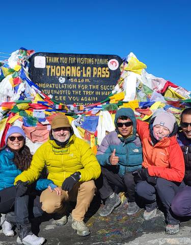 Group of people at Thorong La Pass with prayer flags