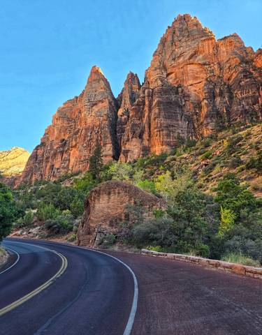 Scenic view of red rock cliffs and green foliage
