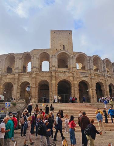 Historic Roman amphitheater filled with tourists.