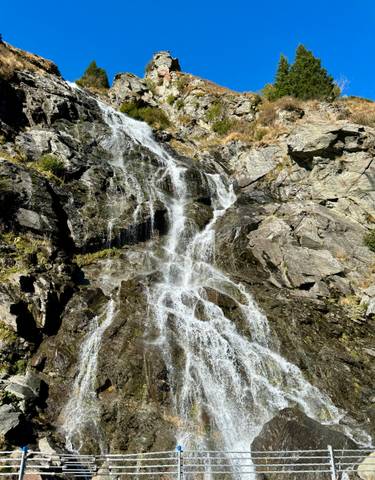Waterfall cascading over rocky cliffs in a natural setting.