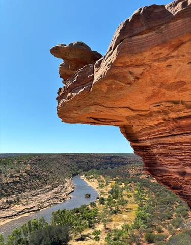 Rocky ledge overlooking a vast canyon landscape.