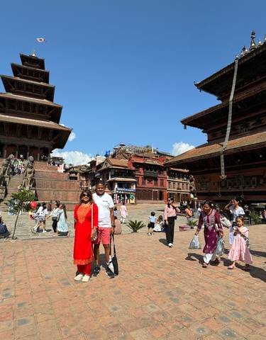 People walking around a historic square with traditional architecture.