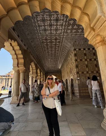 Person standing in a decorative hallway with intricate patterns.