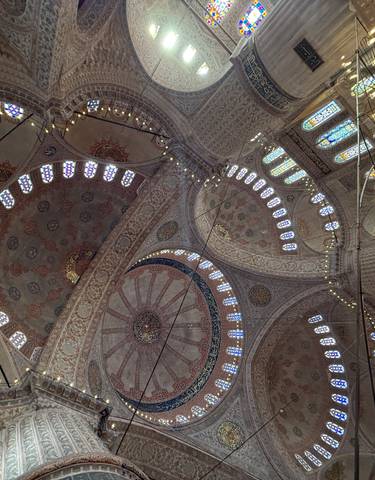 An ornate domed ceiling inside a mosque.