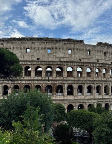 Colosseum in Rome with greenery in foreground.