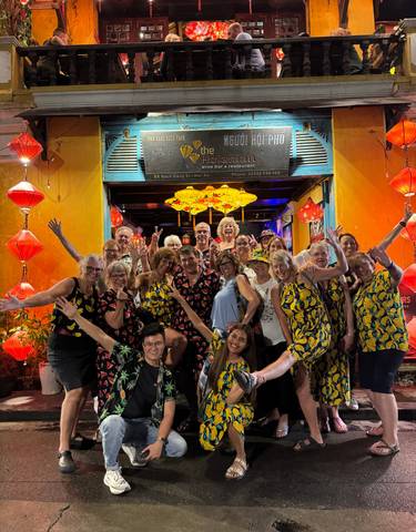 Large group photo in front of a lantern-covered entrance.