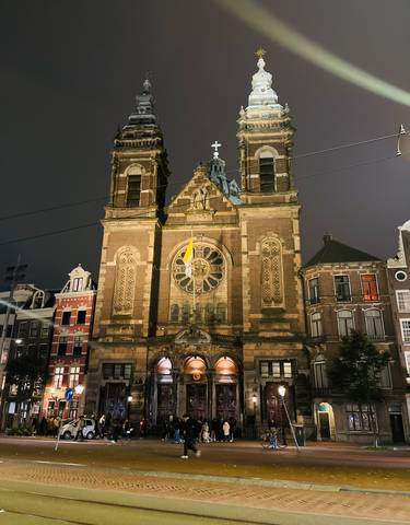A church lit up at night with surrounding buildings.