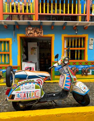 Colorful street facade with a vibrant scooter in front.