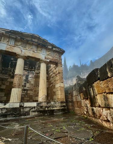 Ancient ruins with columns and stone walls under a blue sky.