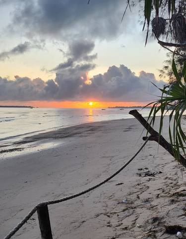 Sunset on a beach with dramatic clouds.