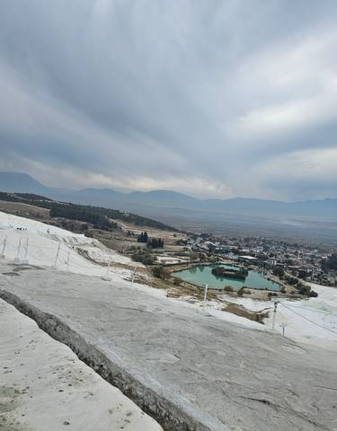 Pamukkale landscape with thermal pools and distant mountains.