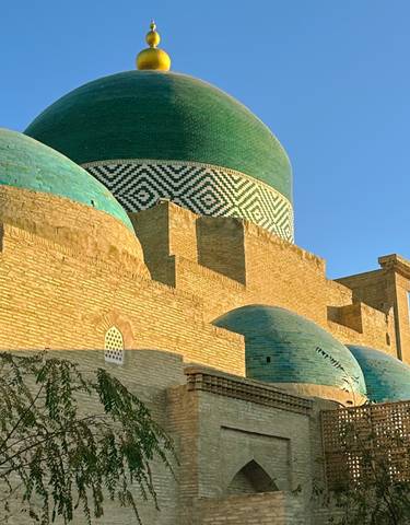 Colorful tiled domes and brickwork against a blue sky.