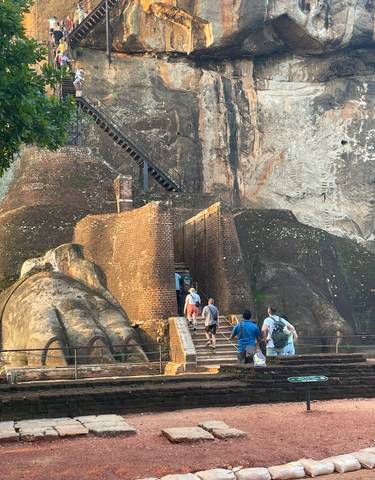 People ascending the ancient rock fortress.