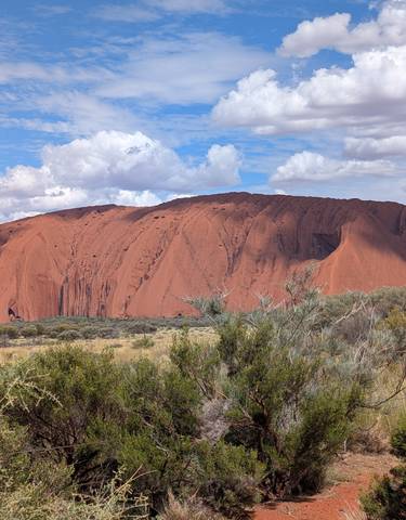Uluru rock formation under a blue sky.