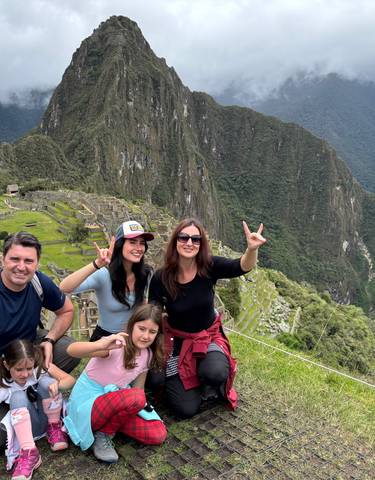 Family posing with Machu Picchu in the background.