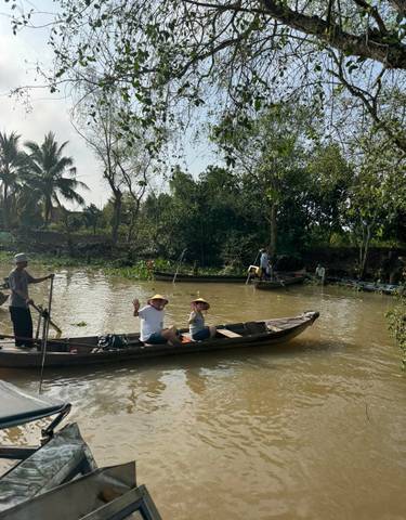 Tourists on boats navigating a narrow waterway.