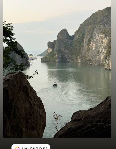 A serene view of a narrow boat navigating a calm river flanked by towering cliffs.