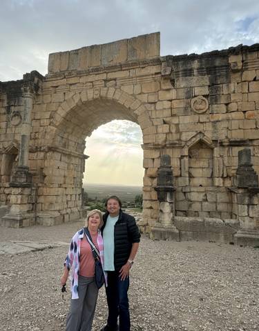 Large stone archway with two people standing in front.