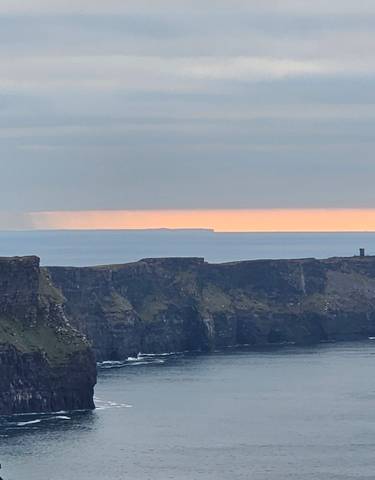 Cliffs of Moher against the ocean under a dramatic sky.
