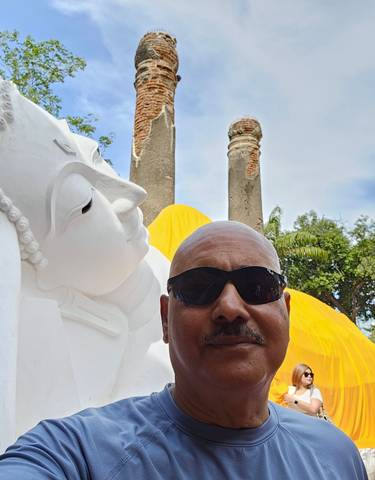 Person in front of a reclining Buddha statue.