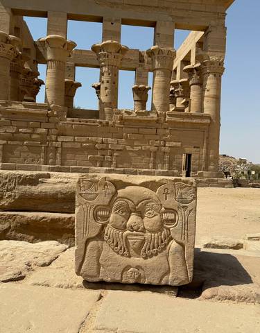 Egyptian temple ruins with carvings and columns in the desert.