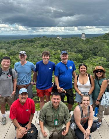 Large group posing with jungle and ancient structures.