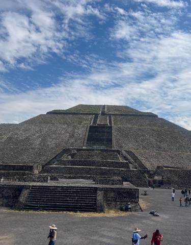 An ancient pyramid structure with people around.