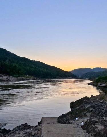 Sunset view over a river surrounded by hills.