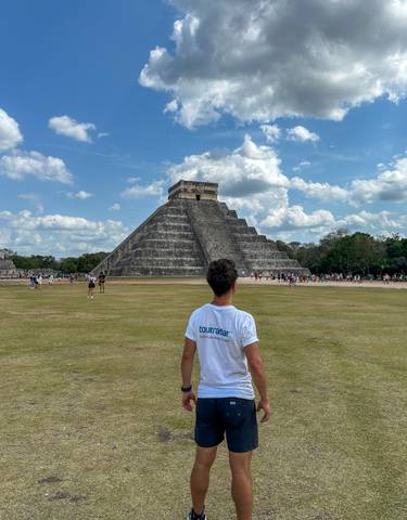 Visitor standing in front of the pyramid at Chichen Itza.