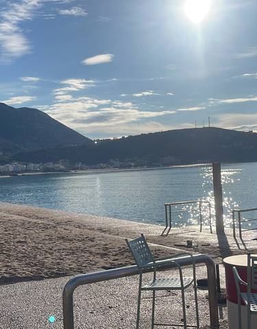 Peaceful beach with mountains in the background.