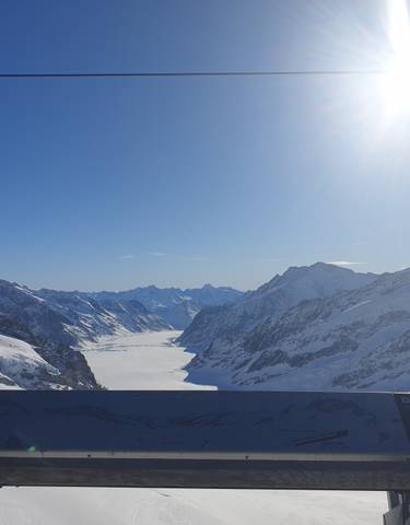 Snow-covered mountain landscape under a clear blue sky.