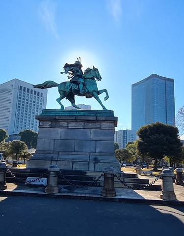 Equestrian statue with skyscrapers in the background.