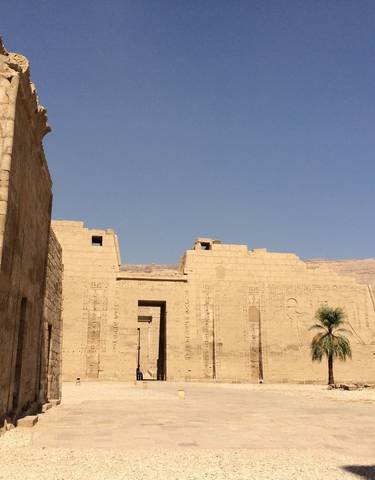 Exterior of a large ancient temple with clear blue sky.