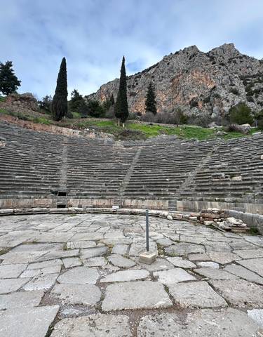 Ancient amphitheater with mountains in the background.