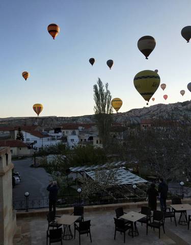 Hot air balloons in the sky over a scenic town landscape.