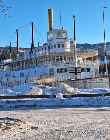 Historic steamship docked in a snowy environment.
