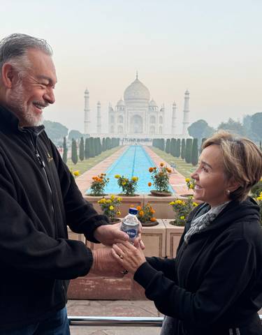 Couple posing in front of the Taj Mahal.