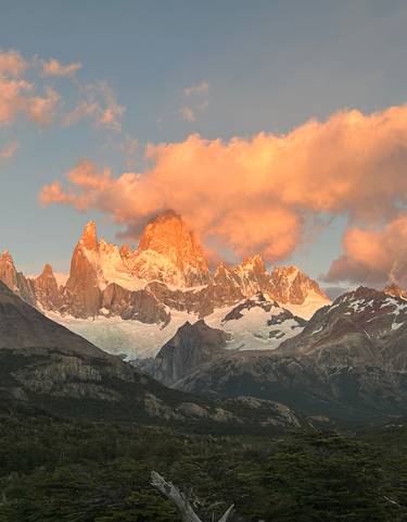 Sunlit mountain peaks with clouds at sunset.