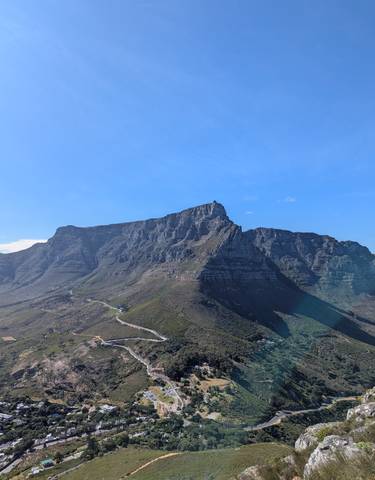 View of a large, rugged mountain range under a clear blue sky.