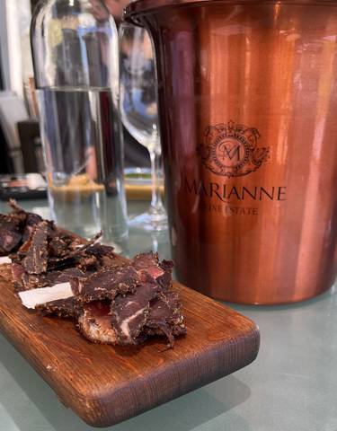 A close-up of a tray with food in front of a wine estate ice bucket.