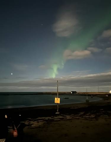 Northern lights over a coastal area at night.
