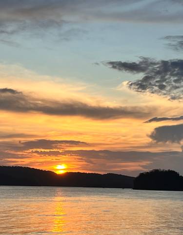 Beautiful sunset with the sun setting over the horizon and dramatic clouds.