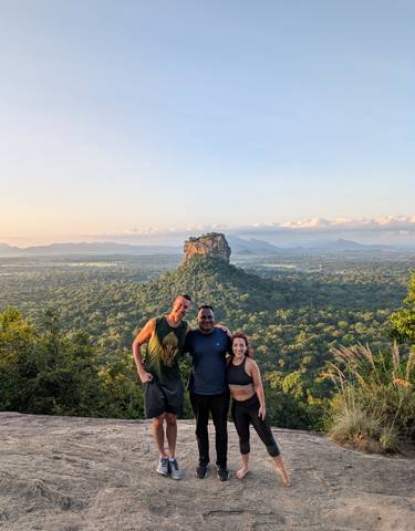 Group posing with a view of Sigiriya in the background.