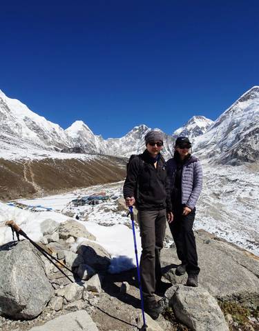 Two people in winter clothes on a snowy mountain path.