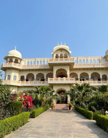 A grand palace with lush gardens and flowers.