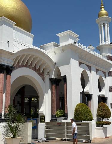 White building with arches and intricate detailing.