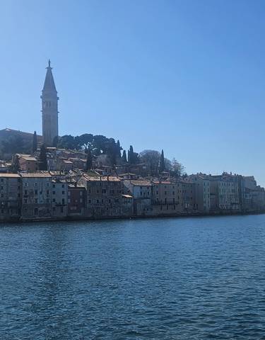 A coastal town with medieval architecture against a clear sky.