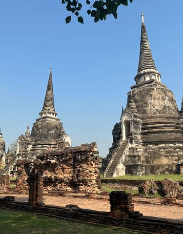 Ancient temple ruins with spires under a clear blue sky.